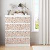 A white cabinet decorated with vintage floral peel-and-stick wallpaper featuring soft pink and green botanical patterns.