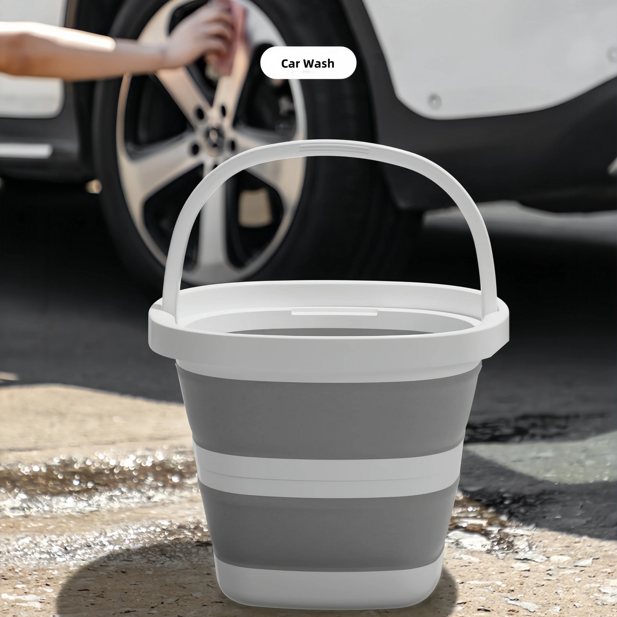 A white collapsible outdoor bucket with a handle is shown on a concrete surface.