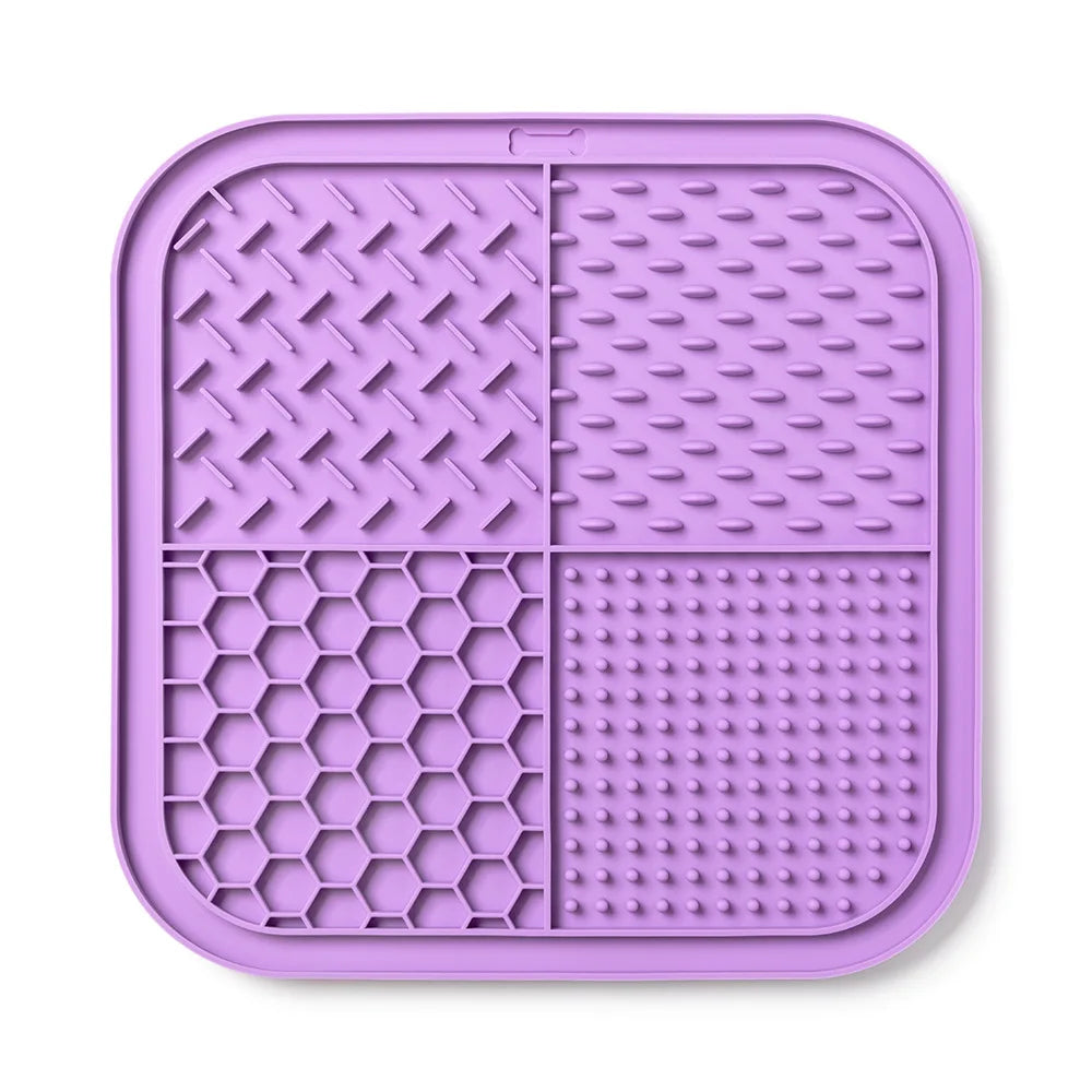 A purple silicone lick mat for dogs and cats with suction cups, divided into four textured sections.