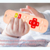 A baby's hand holds an orange silicone teether toy shaped like a remote control with buttons and a list feature.