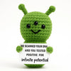 Handmade crochet green hedgehog doll with a white card that reads we scanned your dna and you tested positive for infinite po