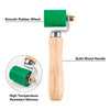 A green silicone handwheel seam roller with a solid wood handle and a smooth rubber wheel.