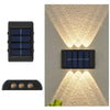 A solar powered outdoor wall light with upward and downward illumination mounted on a textured wall.