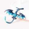 A blue enamel dragon brooch with silver accents and rhinestone details displayed on a white background.