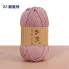A skein of pink cotton blend crochet yarn is shown on a wooden surface.
