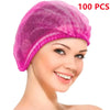 A close-up of a woman wearing a pink disposable bouffant hair cap.