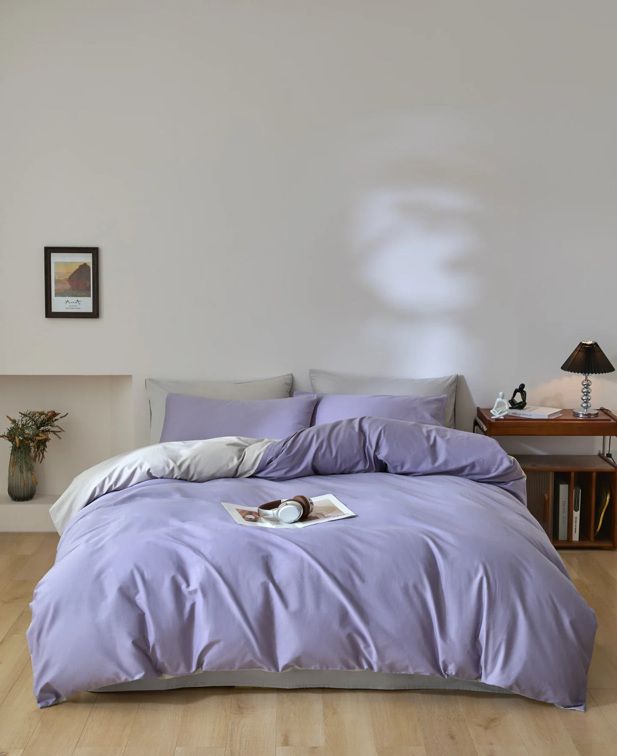A purple quilted duvet cover set with pillows on a bed in a bright room.