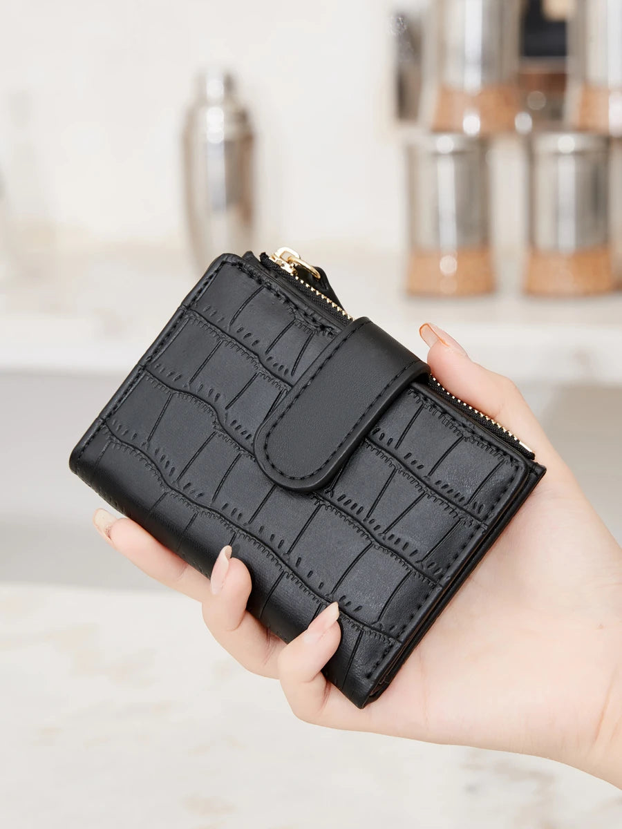 A hand holds a black croc-embossed PU leather bifold wallet.