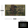 A dark olive green embroidered patch featuring a skull and crossbones design with black stripes and American stars, measuring
