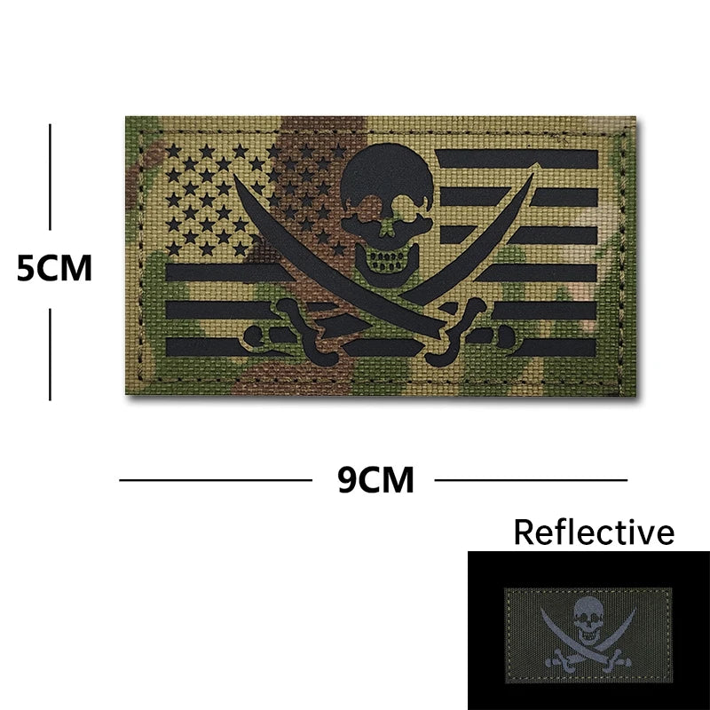 A dark olive green embroidered patch featuring a skull and crossbones design with black stripes and American stars, measuring