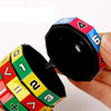 A hand holds a colorful Montessori math cube toy showing numbers and arithmetic symbols.