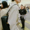 A close-up shot of a beige leather jacket and a black leather crossbody bag with a gold lock.