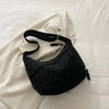 A black leopard print crossbody bag is displayed against a white background with a white blazer.