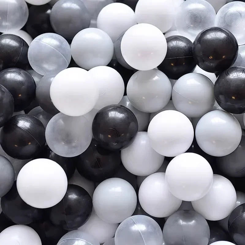 A pile of assorted gray and white ball pit balls for toddlers and kids.