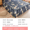 Jupe de lit à motif floral bleu foncé avec ourlet froncé, présentée sur un lit.