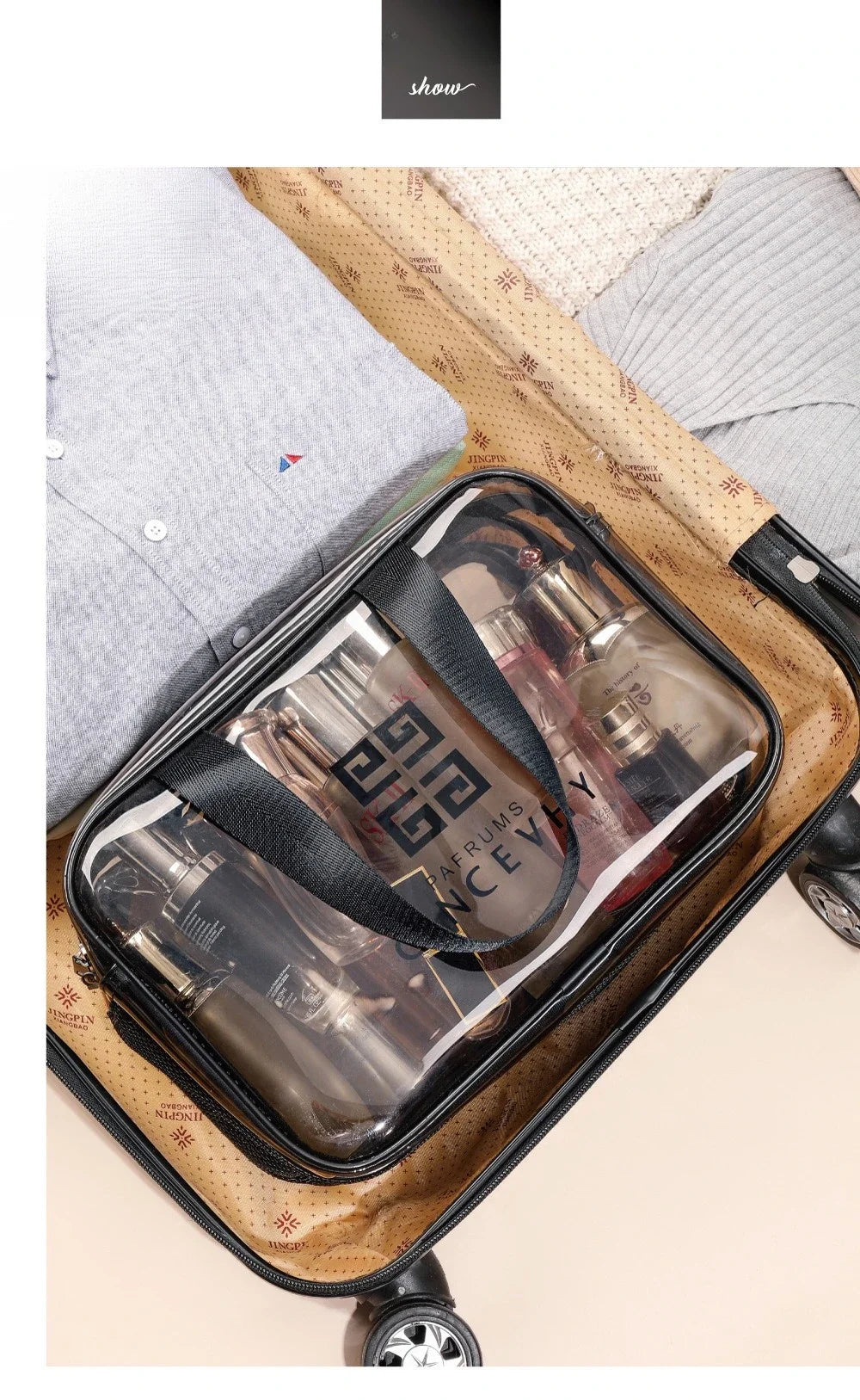 A transparent PVC travel toiletry bag with wet-dry separation is shown resting on a patterned fabric and clothing.