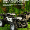 A black six-wheel drive off-road RC car with an alloy body is shown driving through green grass.