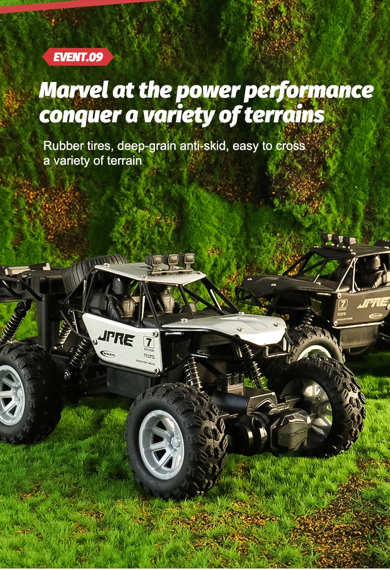 A black six-wheel drive off-road RC car with an alloy body is shown driving through green grass.