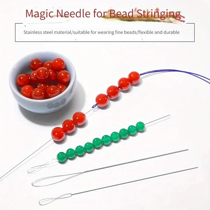 A set of flexible stainless steel bead needles used for stringing beads, shown next to a bowl of red beads.