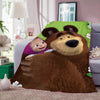 A cartoon illustration of a large brown bear hugging a small child, displayed on a green patterned fleece throw blanket.