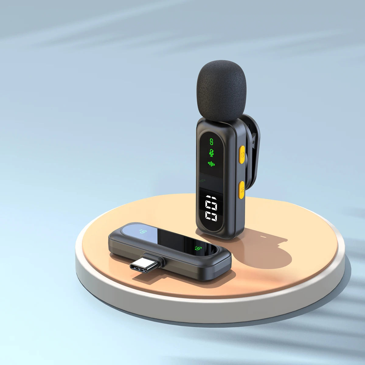 A black wireless lavalier microphone system with a foam windscreen and a transmitter unit resting on a light brown circular b