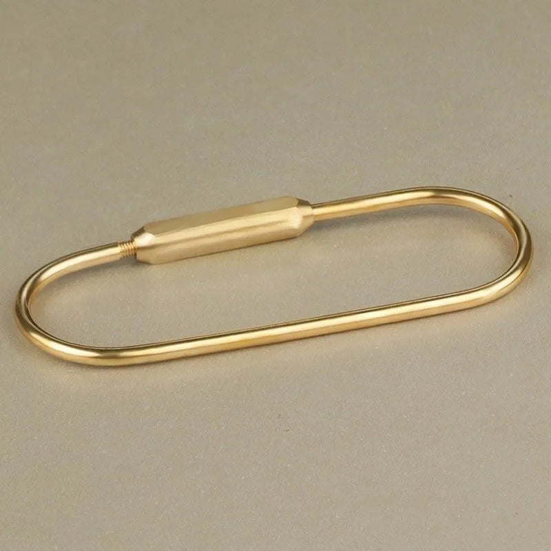 A gold brass keychain charm with a locking carabiner clip.