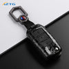 A carbon fiber car key cover with a metal loop and electronic features for VW and Skoda models.