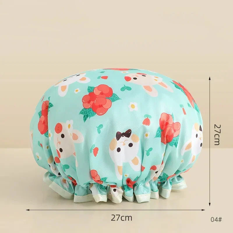 A light mint green reusable waterproof shower cap with a floral pattern shown from the top and side.