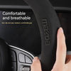 Close-up of a black leather steering wheel cover for a Mazda, highlighting the grip texture and branding.