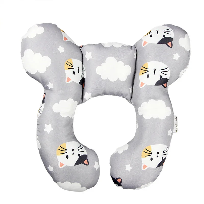 A gray baby head and neck support pillow featuring cute cat faces and clouds for car seat travel.