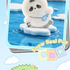 A white snow seal pup plush toy sitting on ice with a blue collar and a blue tag.