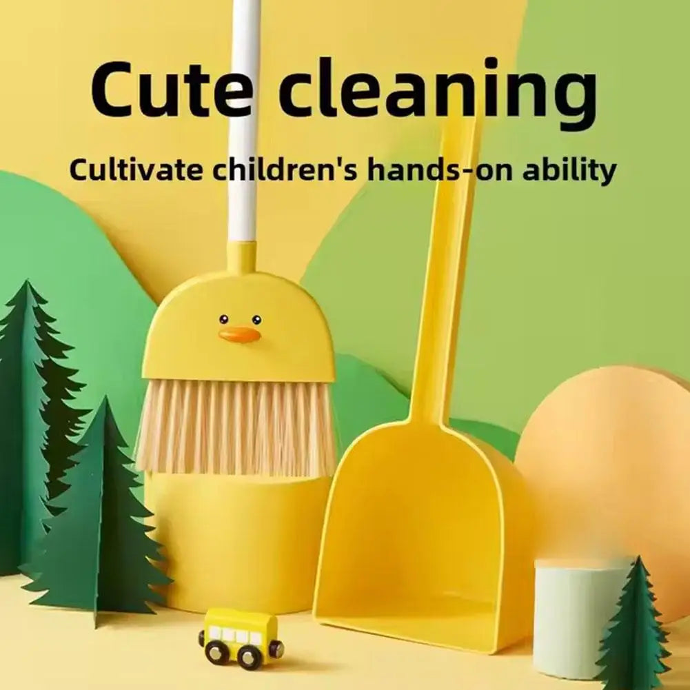 A yellow broom and dustpan set for children, featuring a duck-shaped broom and a yellow scoop, set against a green background