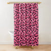 A vibrant pink and black leopard print shower curtain hanging from a gold-toned rod.