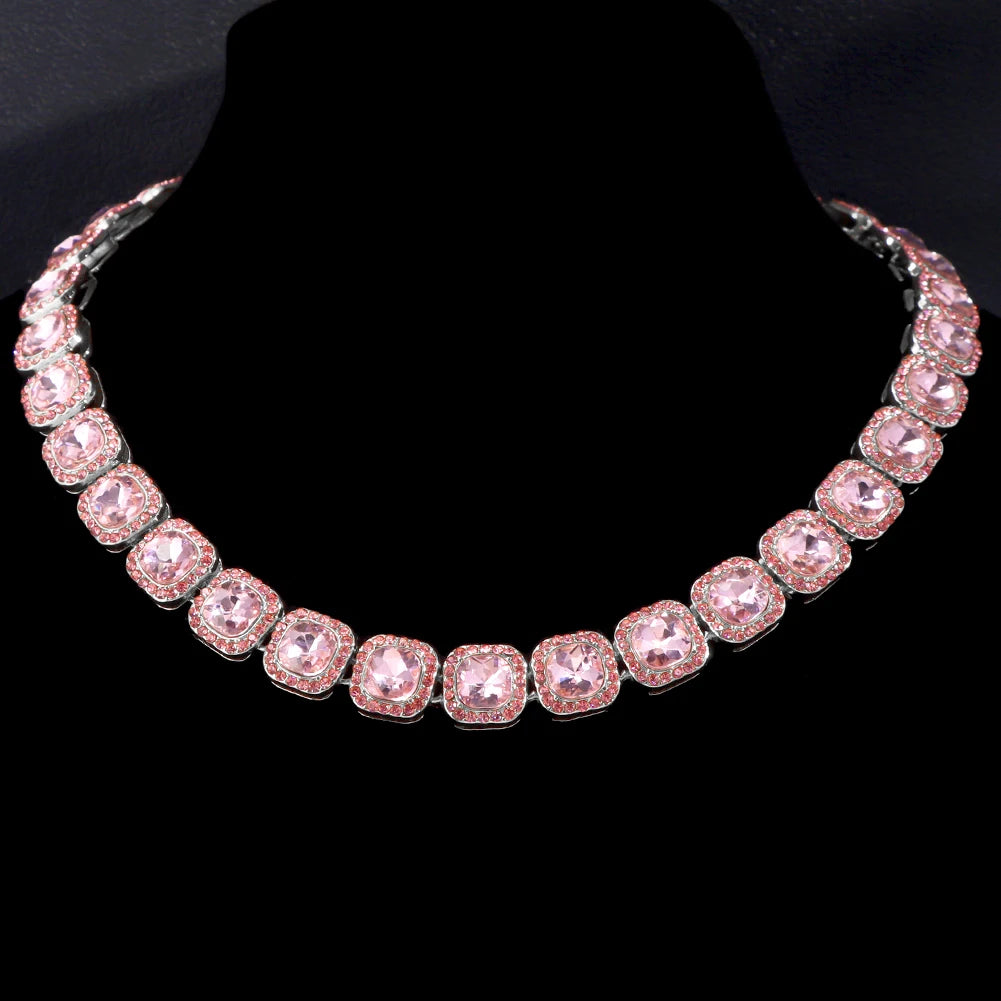 Rapproché d'une chaîne de tennis en strass rose, présentée sur fond noir.