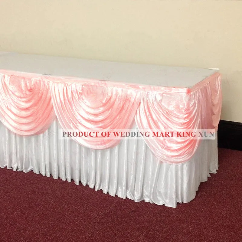 Elegant ice silk table skirt with matching top swag in pink and white for a wedding display.