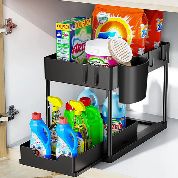 A black two-tier sliding organizer rack for under the sink holding cleaning products and paper towels.