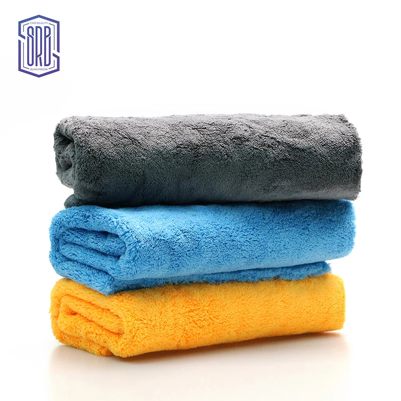 A stack of three colored microfiber cleaning cloths: gray, blue, and yellow.