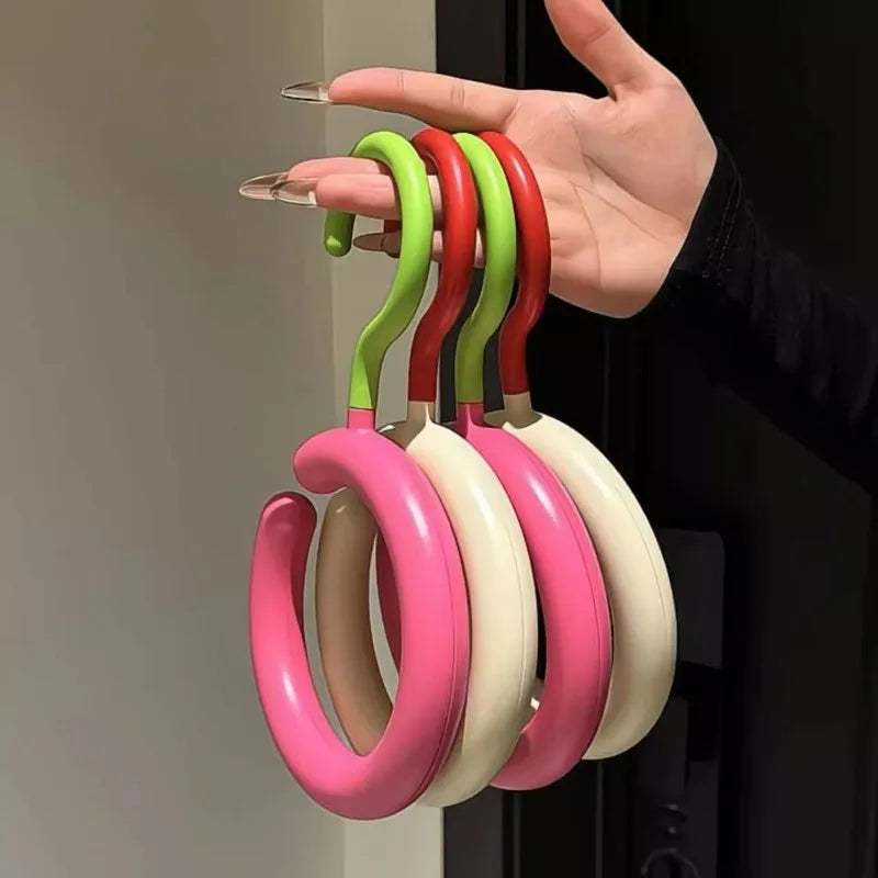 A hand holds a set of colorful, curved hooks for organizing hats and scarves.