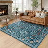 A vintage floral soft area rug featuring blue and green botanical patterns in a living room setting.