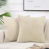 A set of two beige corduroy patchwork throw pillow covers displayed on a white sofa.