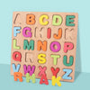 A wooden alphabet puzzle board showing uppercase letters A through Z arranged in a grid.