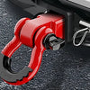 A red heavy-duty shackle hitch receiver with a D-ring and trailer pin mounted on a gray surface.