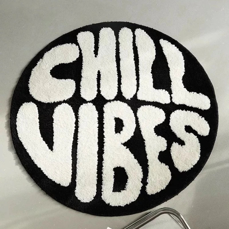 A round black carpet with white fuzzy lettering spelling out CHILL VIBES