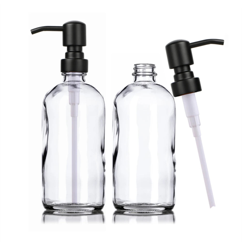 A clear glass soap dispenser set featuring two bottles with black pumps.