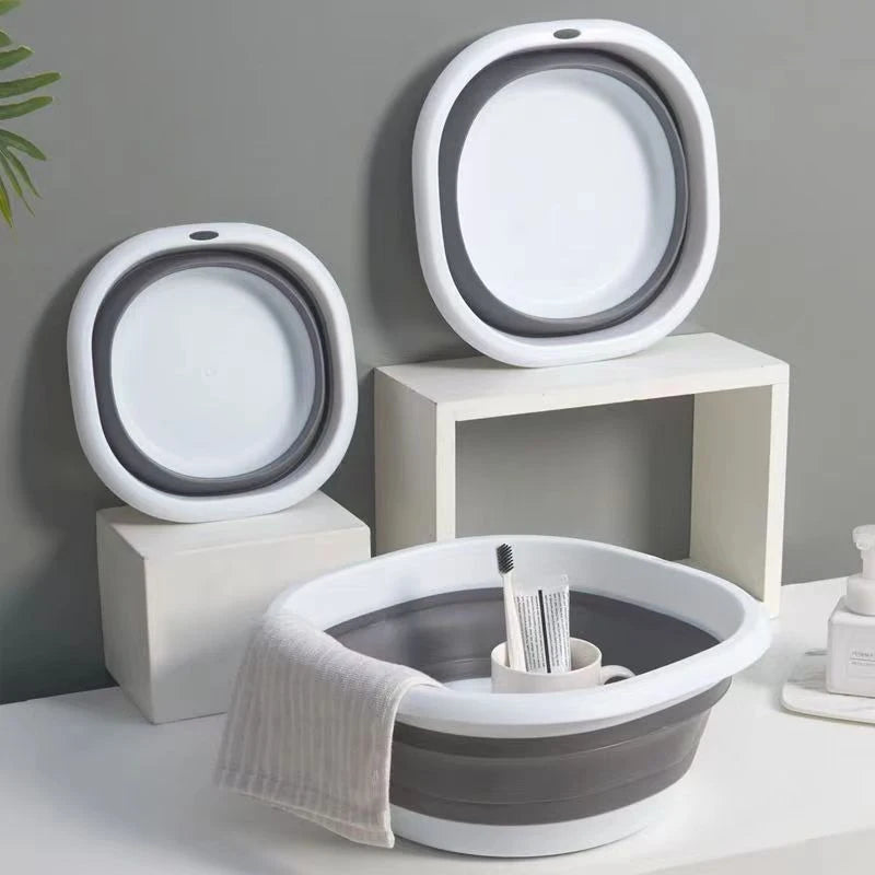 A set of three white and gray foldable plastic wash basins or bowls for laundry, camping, and travel.