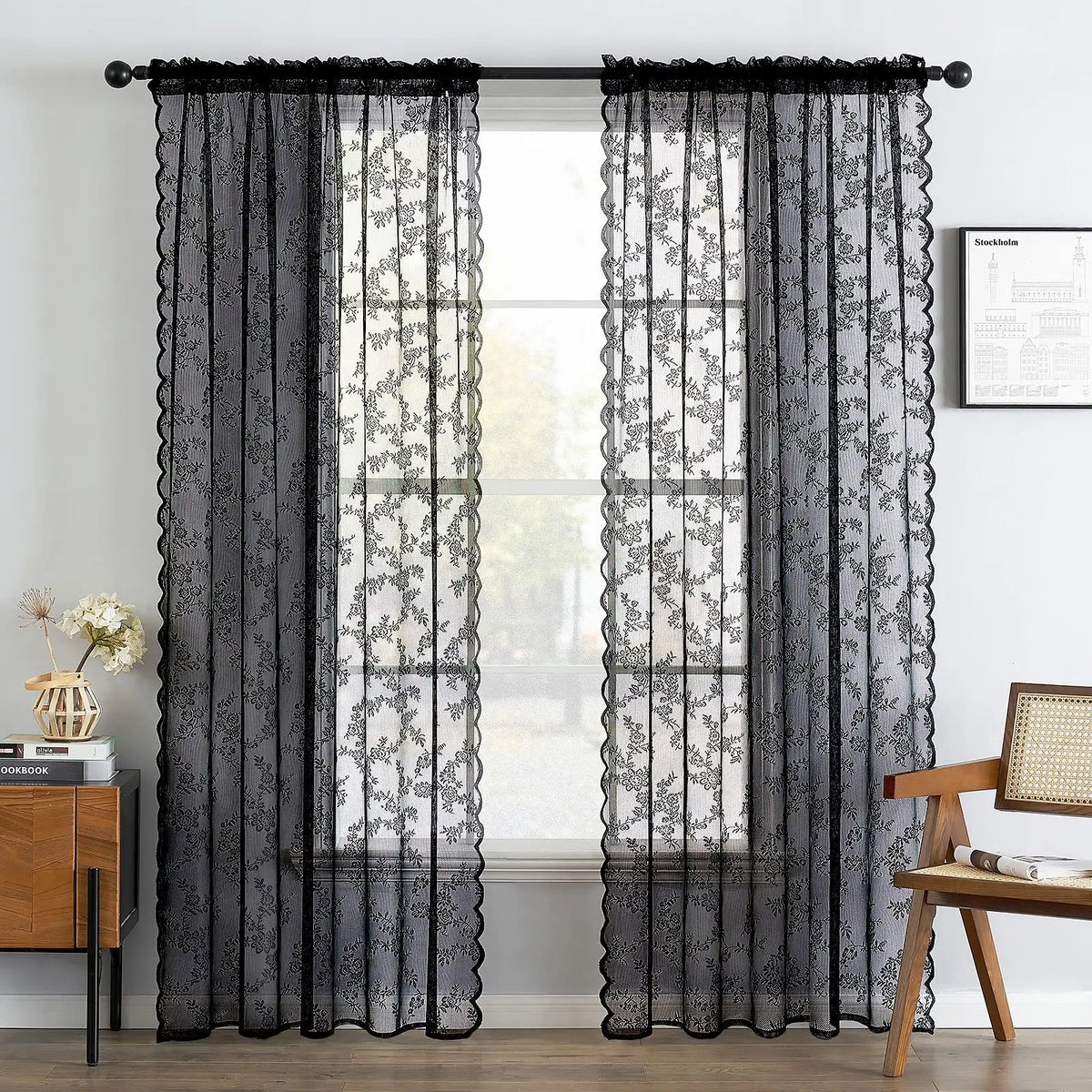 Black sheer floral lace curtain panels hanging over a window.
