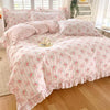Pink floral ruffle cotton duvet cover set displayed on a bed with white window blinds.