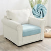 A cream upholstered armchair with a light blue seat cover and a circular blue fabric swirl detail.