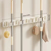 Wall-mounted metal holder for mop and broom with detachable hooks and storage shelves