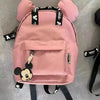 A pink Mickey Mouse themed backpack with a cow print design and black straps.